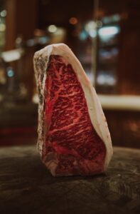 Close-up of a marbled rib eye steak, showcasing its rich texture and premium quality.
